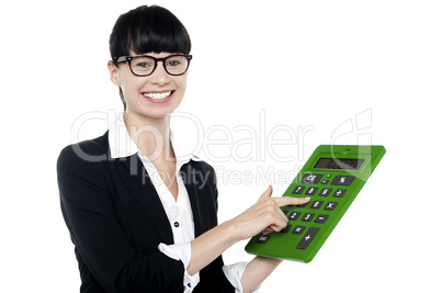 Bespectacled woman using big green calculator