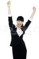 Jubilant corporate lady throwing up her hands