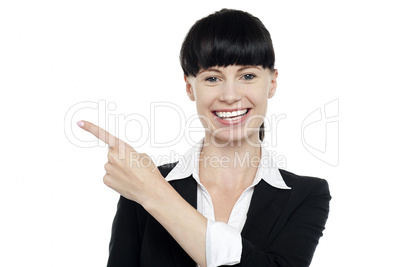 Charming brunette lady pointing towards the copy space
