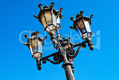 Ornate Spanish lamp post against blue sky