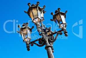 Ornate Spanish lamp post against blue sky