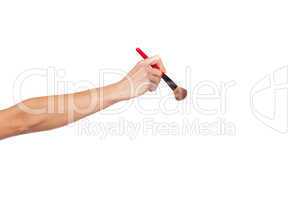 Female hand holding make-up brush