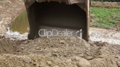 Close-up of an Excavator Bucket Digging in the Dirt