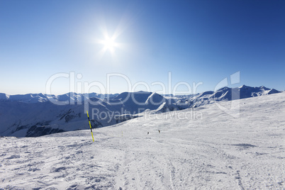 Ski slope and blue sky with sun