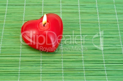 Heart of candles on bamboo