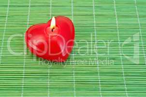 Heart of candles on bamboo
