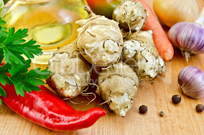 Jerusalem artichokes with vegetables and oil on board