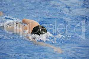 Young man swimming the front crawl in a pool
