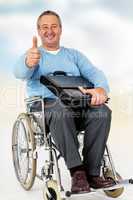 Friendly man in wheelchair holding thumbs up