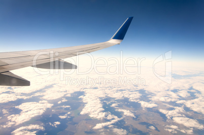 Airplane in clouds above earth