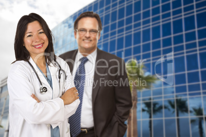 Hispanic Doctor or Nurse and Businessman in Front of Building
