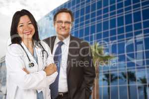 Hispanic Doctor or Nurse and Businessman in Front of Building