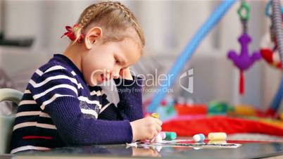 Little girl painting in concentration