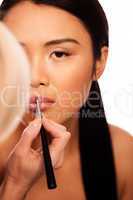 Beautfiul Asian woman applying lipstick