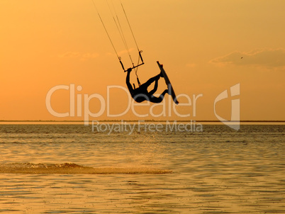Silhouette of a kitesurf, a flying above water of a gulf
