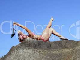 The sexual girl lays on a rock and is played by a shoe
