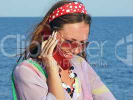 The beautiful girl talks by a mobile phone on the sea