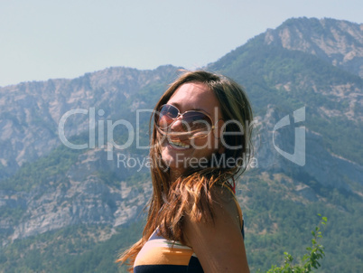 Portrait of the smiling beautiful girl on a background of mounta