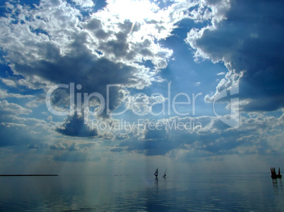 The sky and the sun in clouds above a gulf