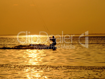 Silhouette of a kite-surf on waves of a gulf on a sunset 1