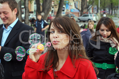 The young girl starts up soap bubble