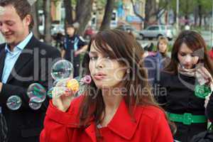 The young girl starts up soap bubble