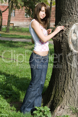 The beauty girl standing near a tree