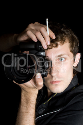 The young man - photographer behind work. Isolated on a black ba