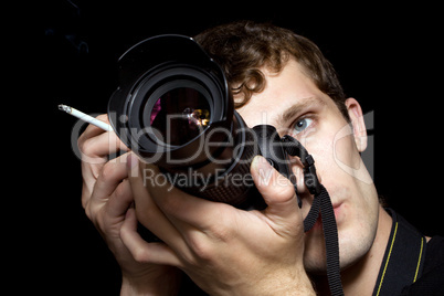 The young man - photographer behind work. Isolated on a black ba