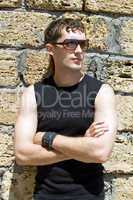 Young man in sunglasses standing near a wall 2