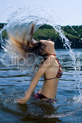 The young woman bathes in the river