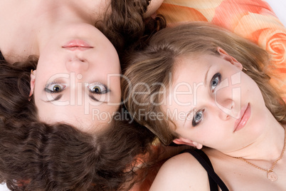 Portrait of the two beauty young women laying on a pillow 1