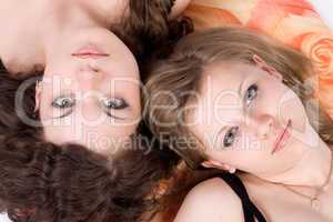 Portrait of the two beauty young women laying on a pillow 1