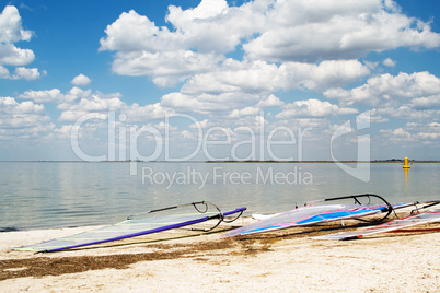 Surfboards on a beach a sea bay on background of the blue sky an