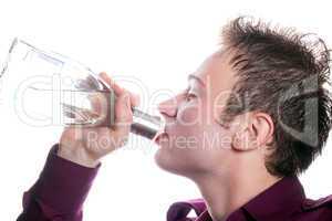 The young man drinks vodka from a bottle