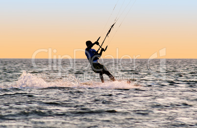 Silhouette of a kitesurfer on waves of a gulf