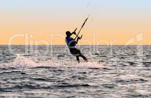 Silhouette of a kitesurfer on waves of a gulf