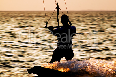 Silhouette of a kitesurfer on a gulf