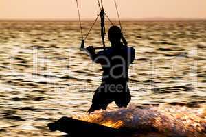 Silhouette of a kitesurfer on a gulf