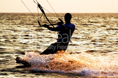 Silhouette of a kitesurfer on a waves