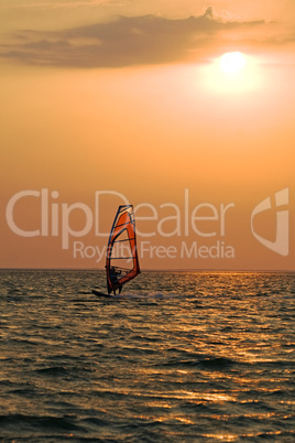 Silhouette of a windsurfer on a gulf on a sunset