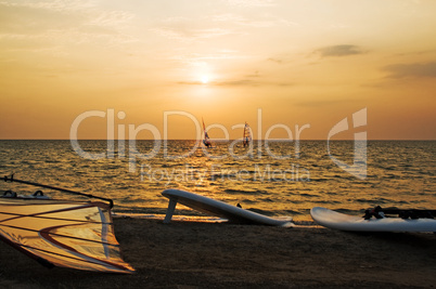 Silhouette of a two windsurfer on a gulf on a sunset