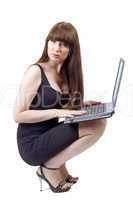 The young businesswoman sits with the laptop in a lap