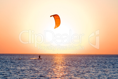 Silhouette of a kitesurfer on a gulf on a sunset