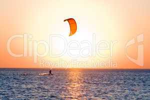 Silhouette of a kitesurfer on a gulf on a sunset