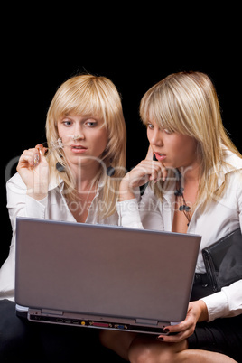 Two young businesswomen sitting with laptop. Isolated