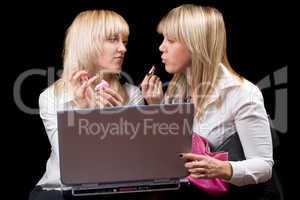 Two blondes do makeup in front of the laptop screen. Isolated