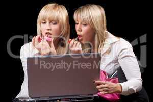 Two blondes do makeup in front of the laptop screen