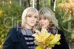 Portrait of the two young women with autumn leaves