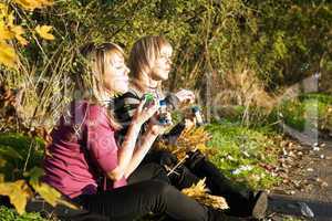 Two young women starts up soap bubble in park